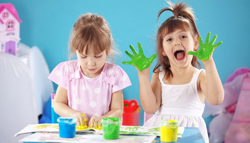 Zdjęcie przedstawia dzieci malujące farbami.
