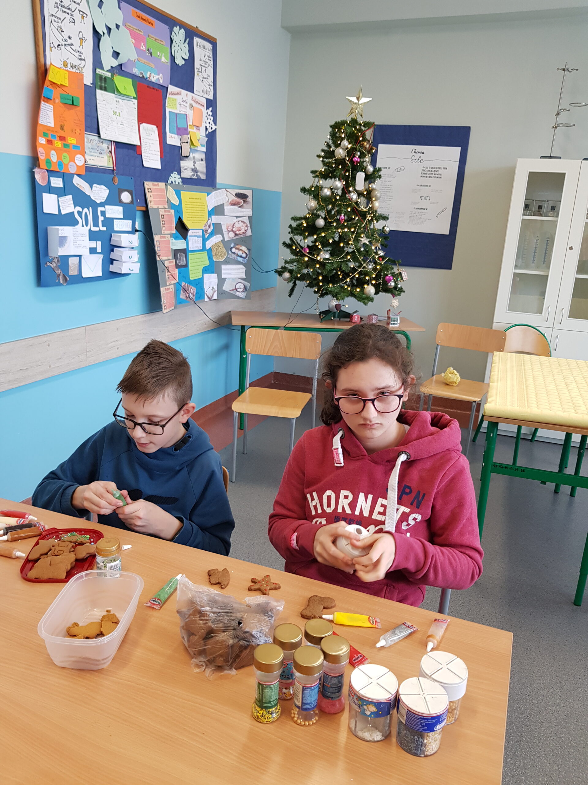 Zdjęcie przedstawia uczniów klasy 7a podczas przygotowywania świątecznych ciasteczek.