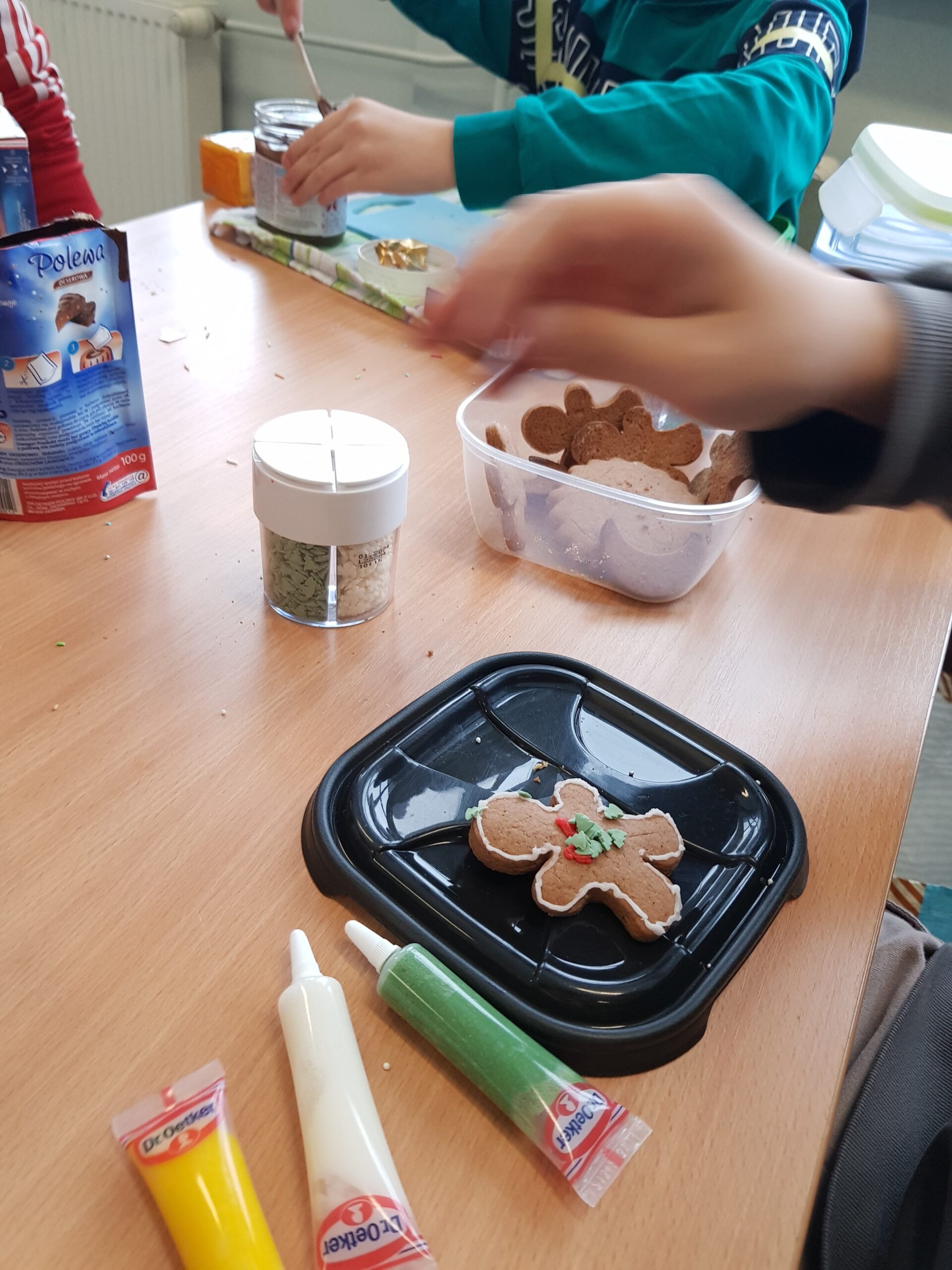 Zdjęcie przedstawia uczniów klasy 7a podczas przygotowywania świątecznych ciasteczek.