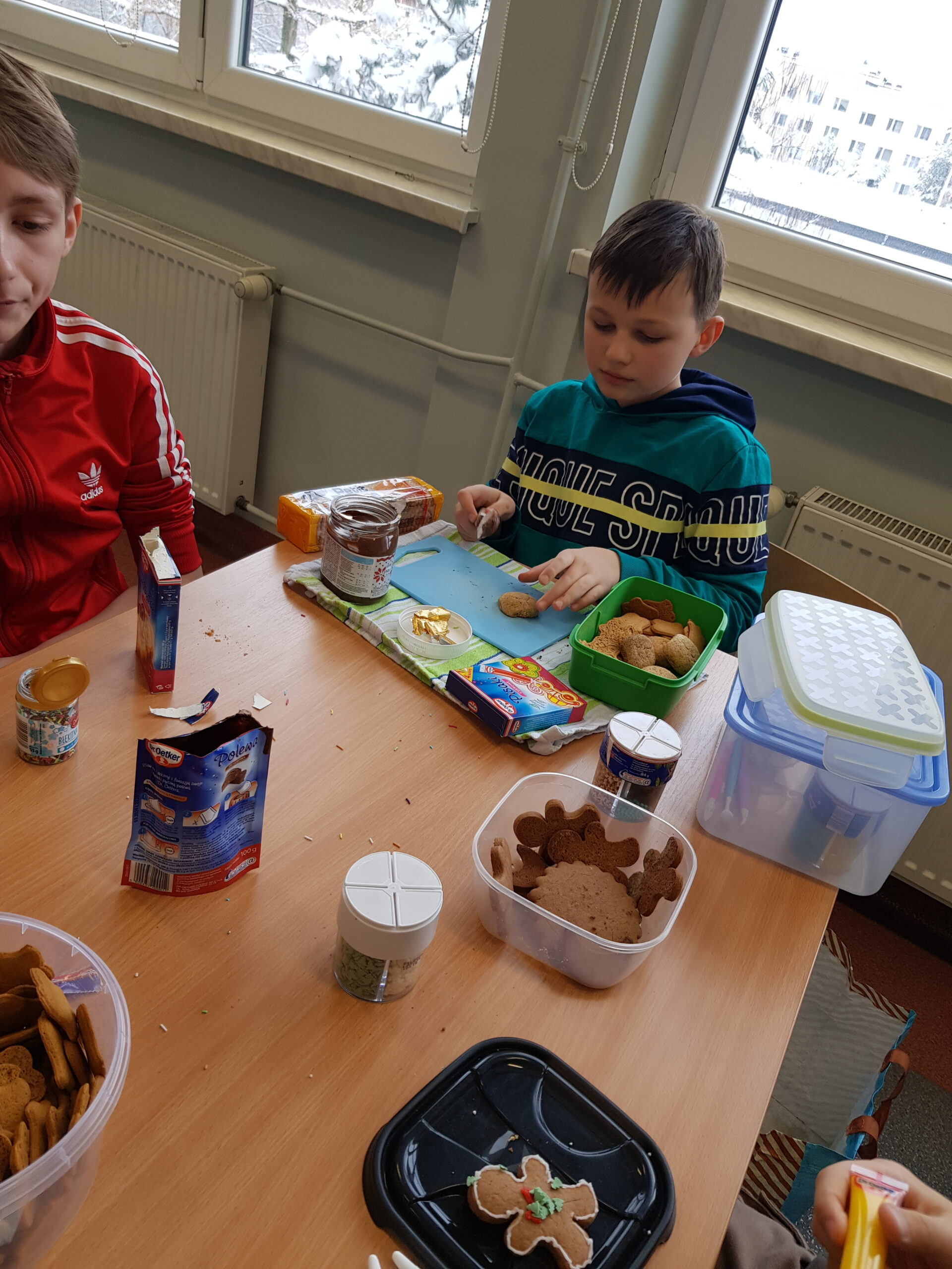 Zdjęcie przedstawia uczniów klasy 7a podczas przygotowywania świątecznych ciasteczek.