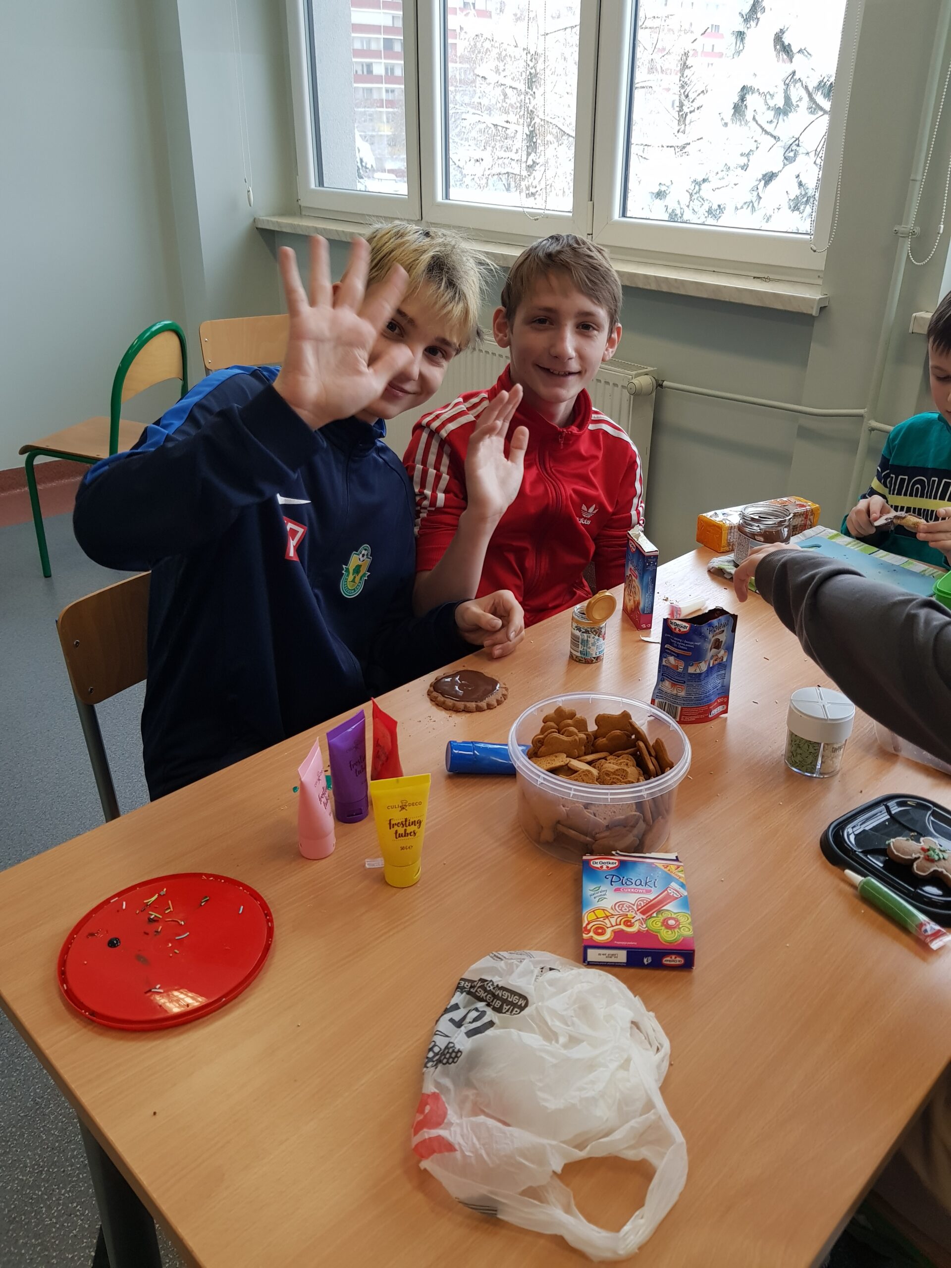 Zdjęcie przedstawia uczniów klasy 7a podczas przygotowywania świątecznych ciasteczek.