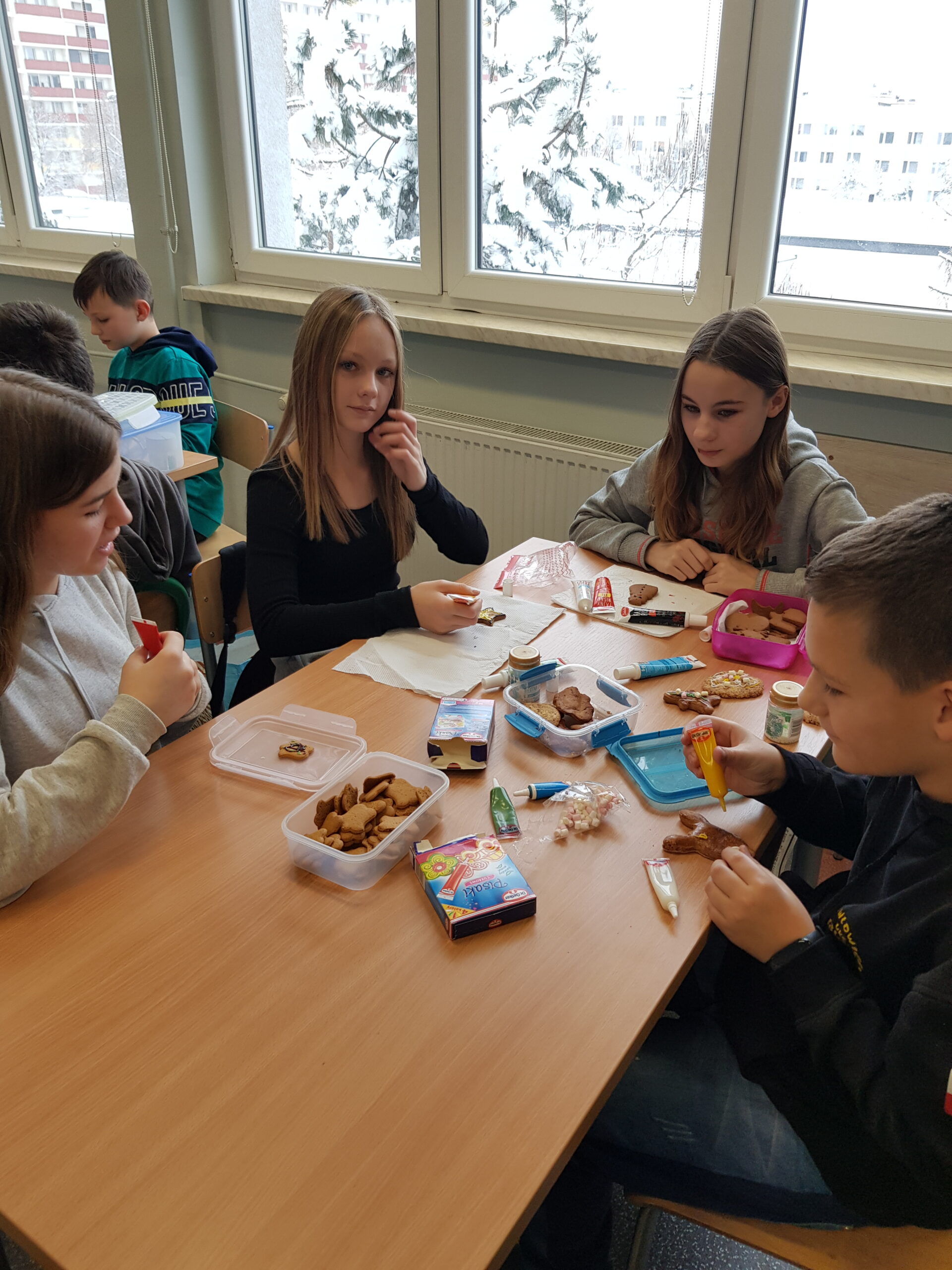 Zdjęcie przedstawia uczniów klasy 7a podczas przygotowywania świątecznych ciasteczek.