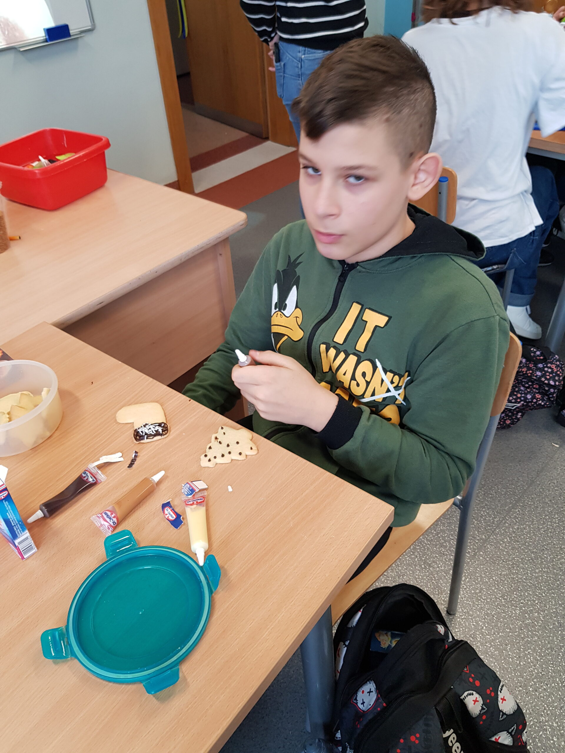 Zdjęcie przedstawia uczniów klasy 7a podczas przygotowywania świątecznych ciasteczek.