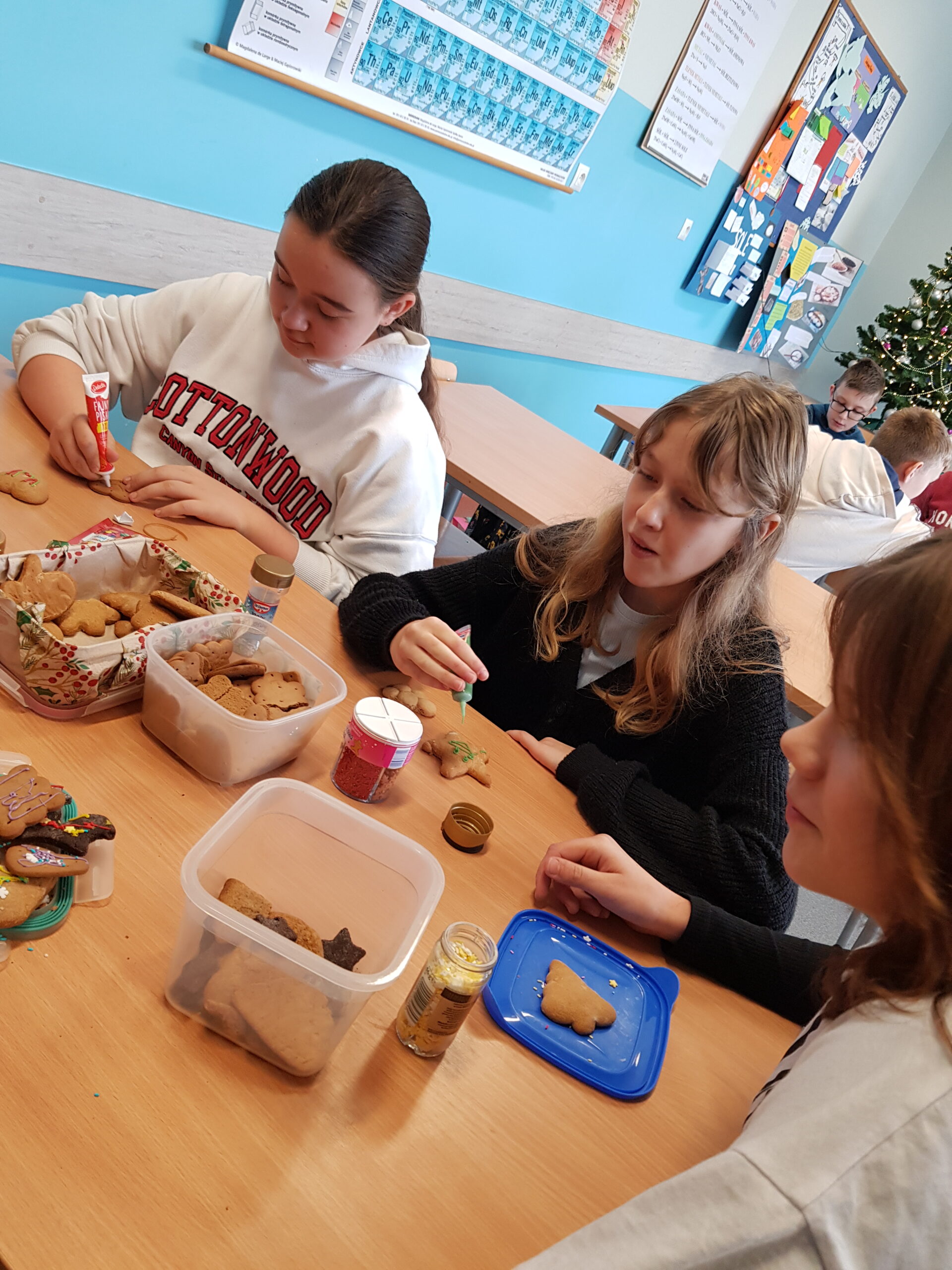 Zdjęcie przedstawia uczniów klasy 7a podczas przygotowywania świątecznych ciasteczek.