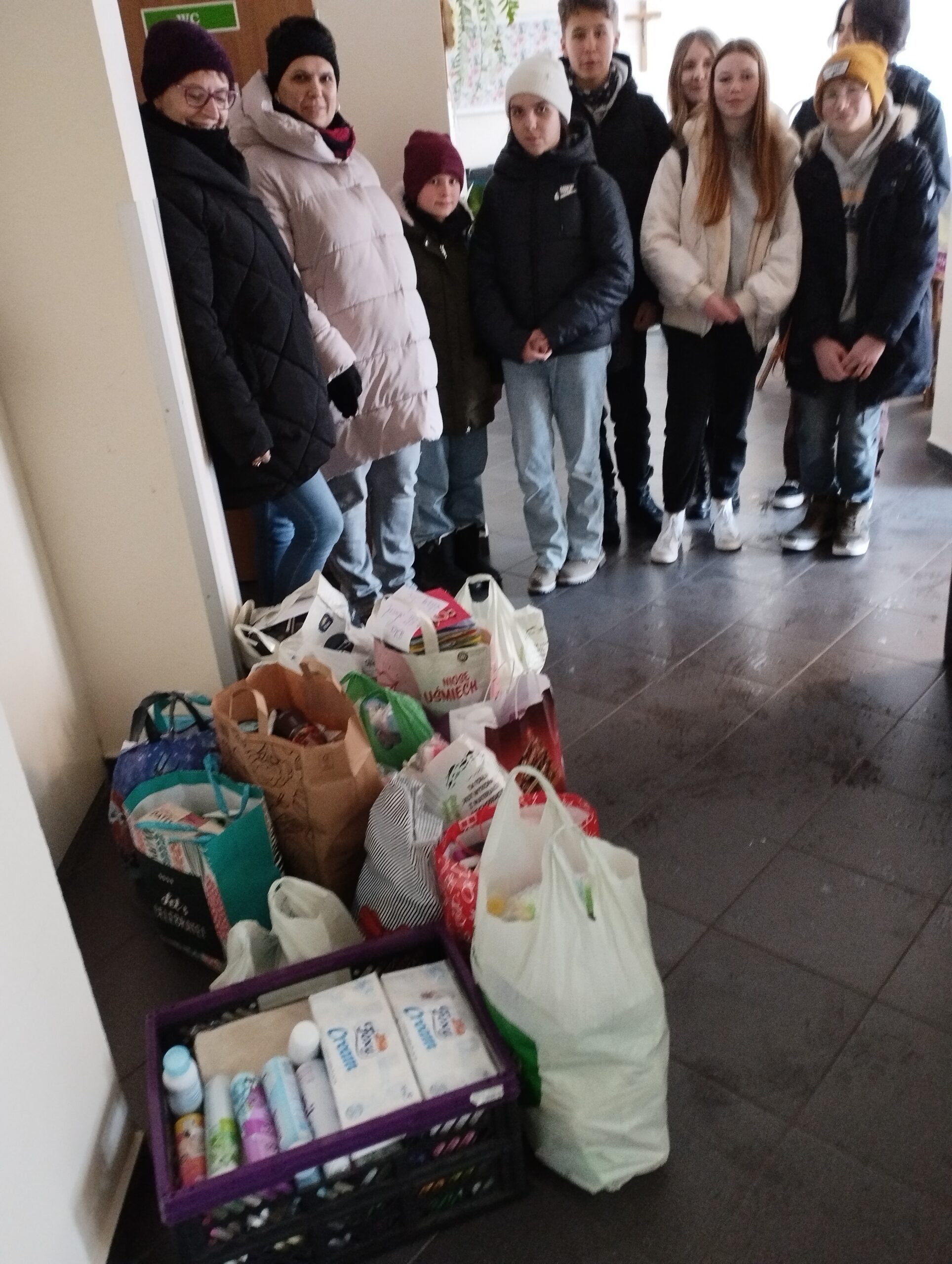 Zdjęcie przedstawia uczniów, rodziców i pracowników szkoły z darami dla podopiecznych Domu Pomocy Społecznej w Żorach.