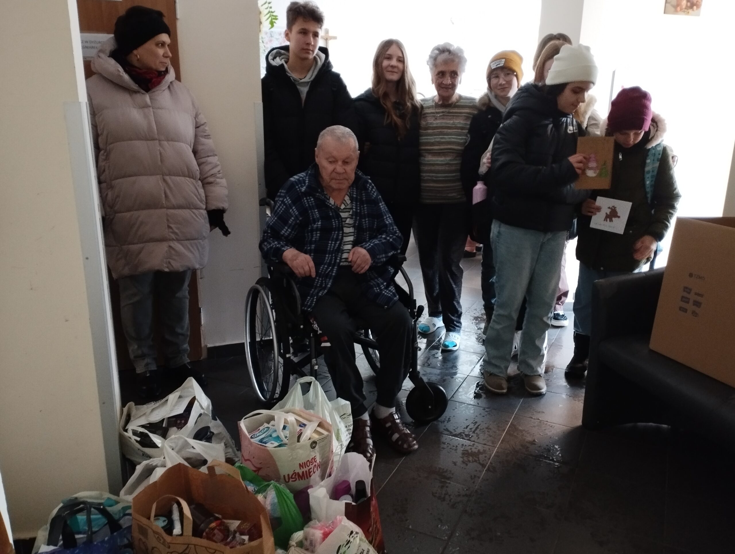 Zdjęcie przedstawia uczniów szkolnego koła wolontariatu, przedstawiciela Rady Rodziców i podopiecznych Domu Pomocy Społecznej w Żorach.