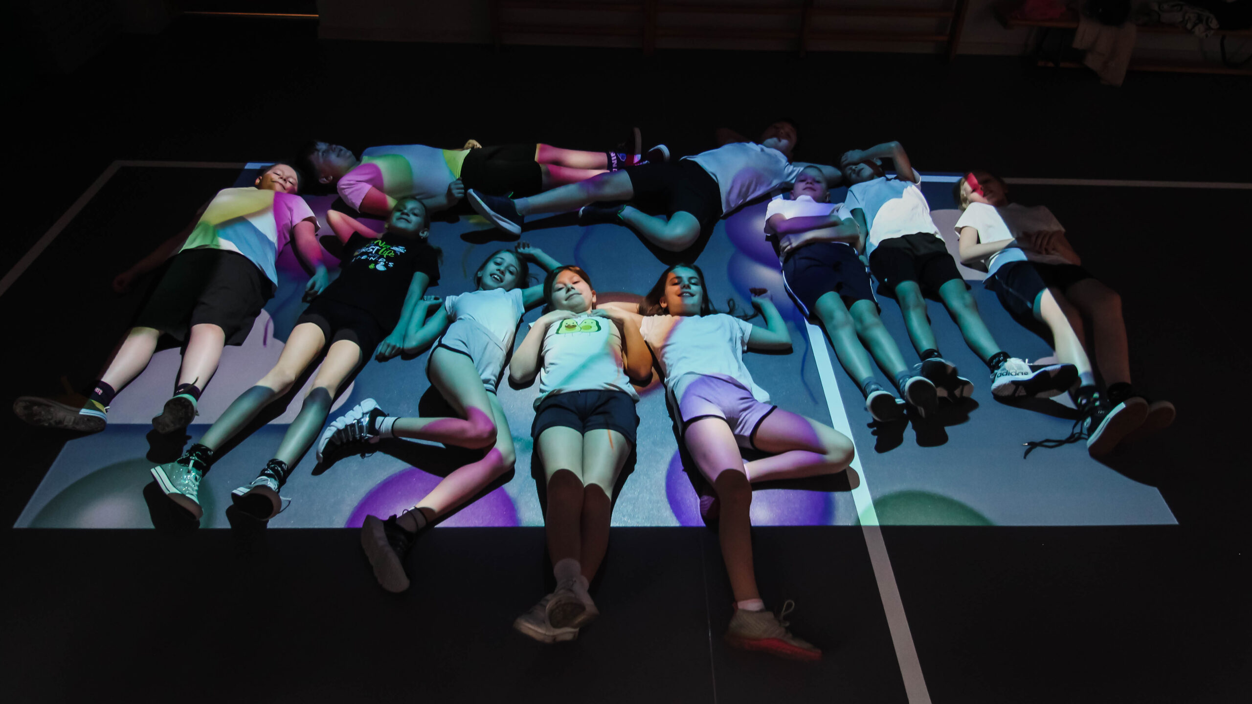 Zdjęcie przedstawia uczniów i uczennice, którzy wykonują różne aktywności, korzystając z Magicznego Dywanu.