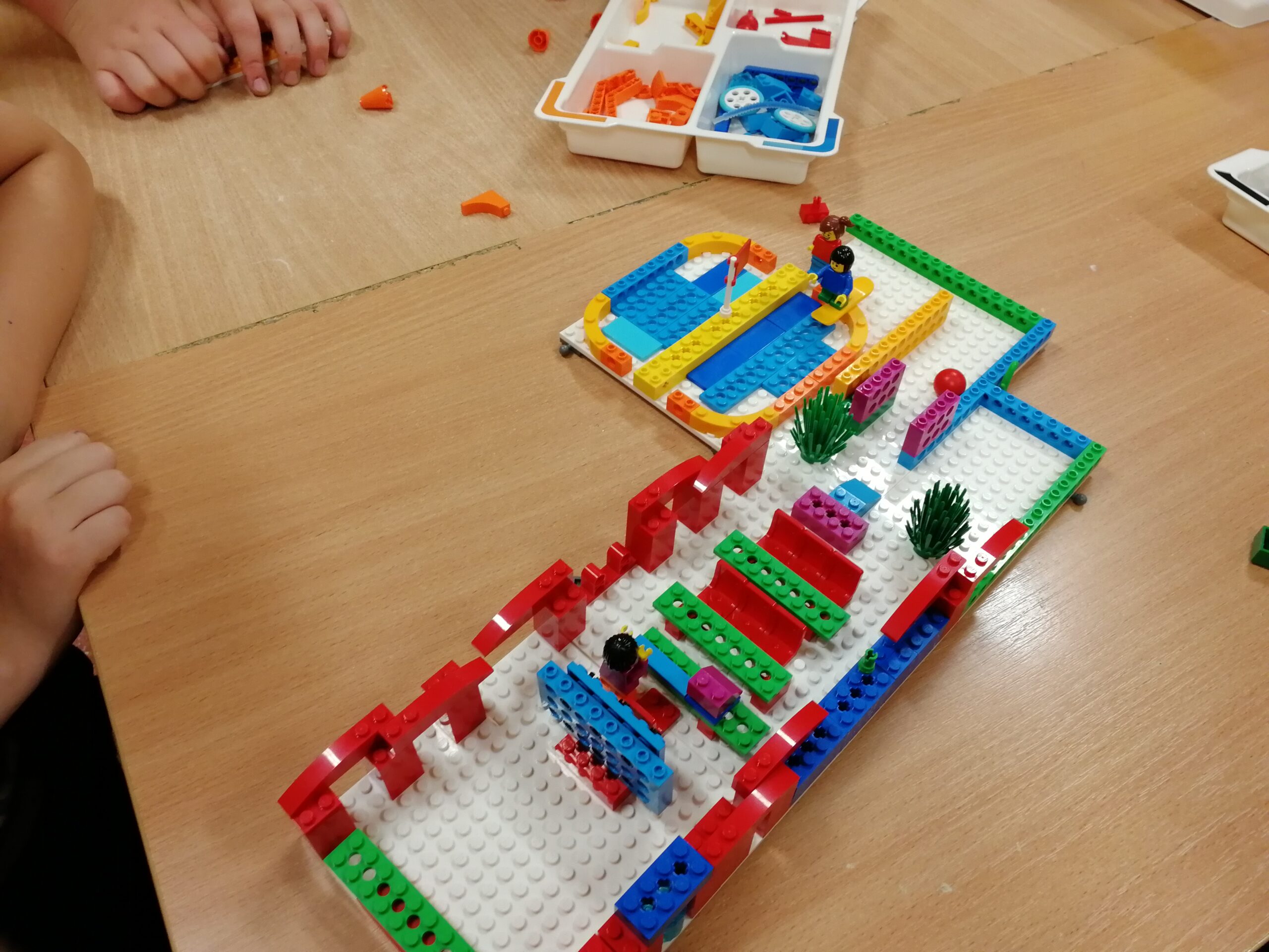 Uczniowie klasy 5b projektują szkołę marzeń z wykorzystaniem klocków lego.