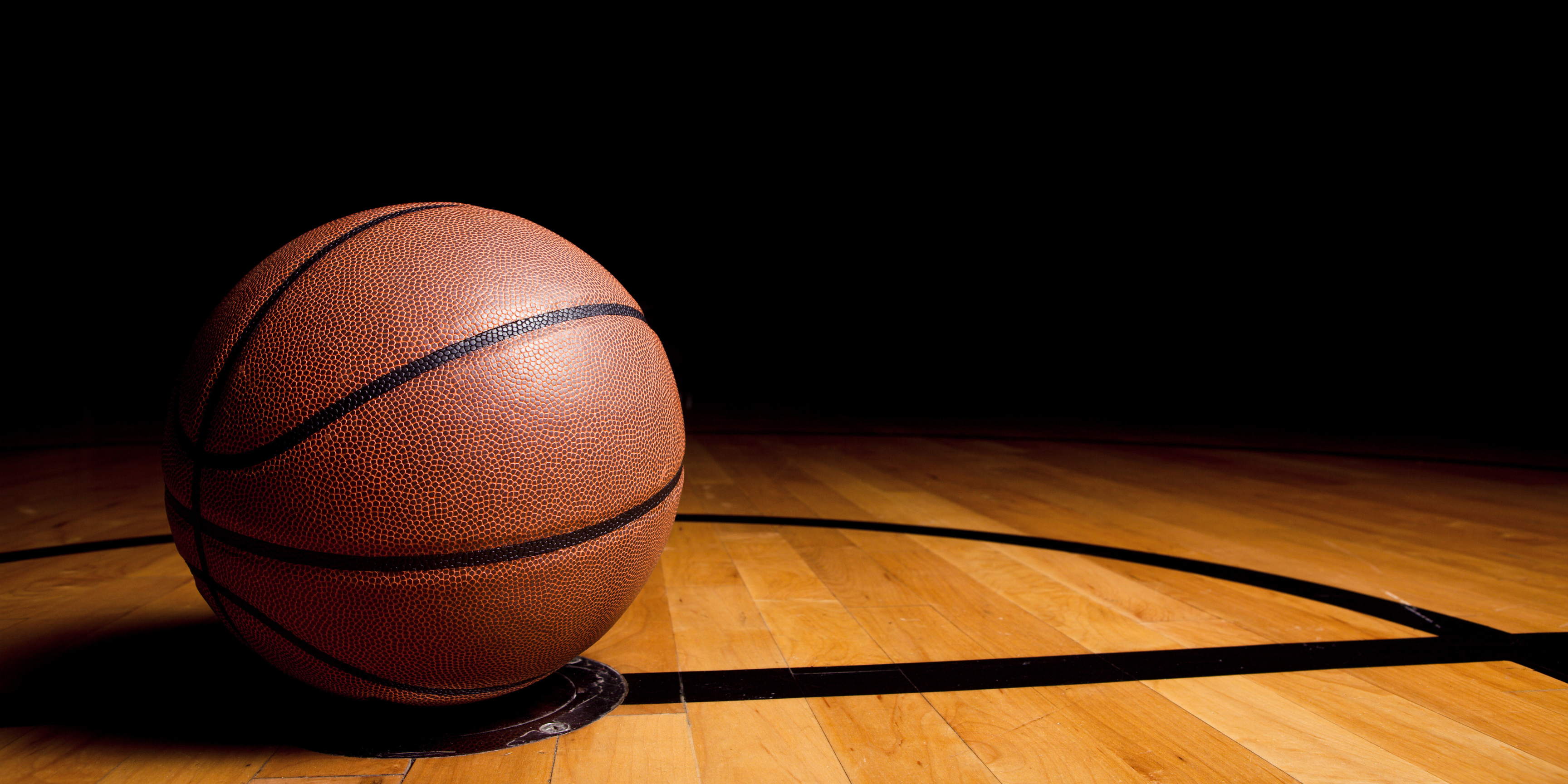 Piłka do koszykówki na parkiecie.