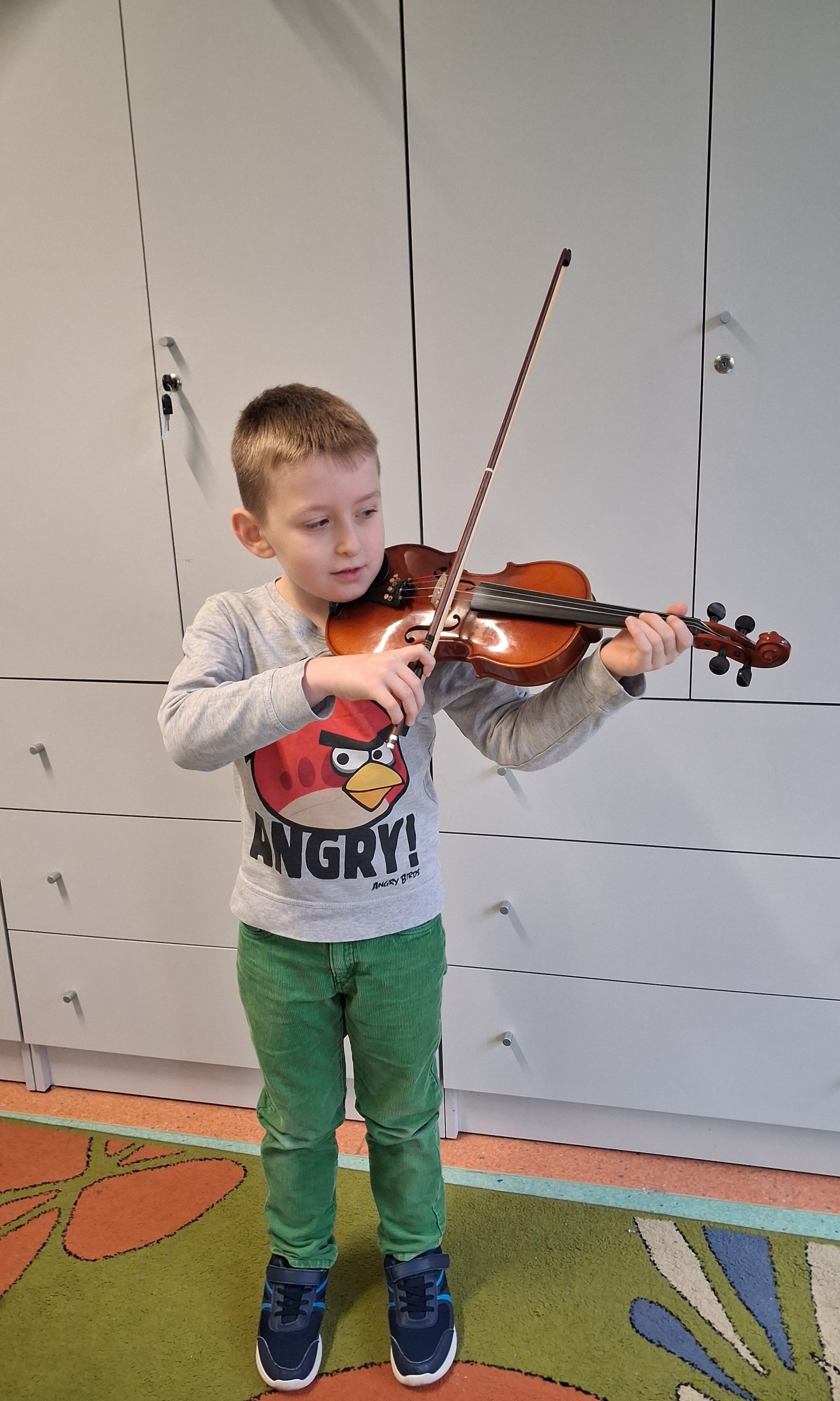 Wiktor gra na skrzypcach.
